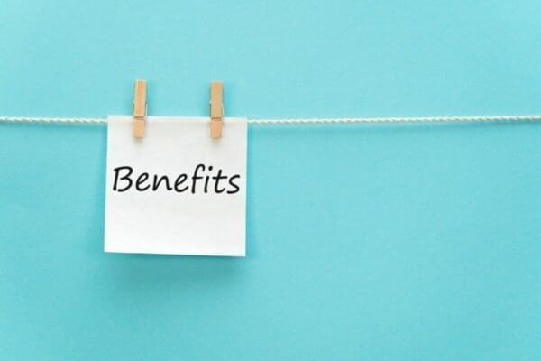 Benefits written in white note pinned to a line with a blue background