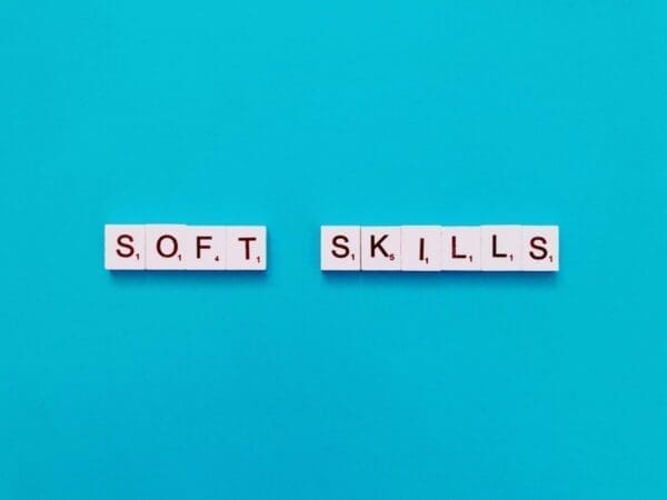 Soft skills spelled with word scramble tiles on blue background
