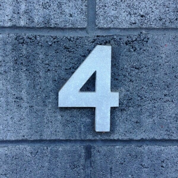 Blue number four on a grey stone wall.