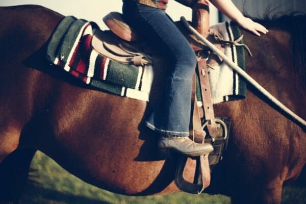 Feet of a rider in stirrups riding a horse