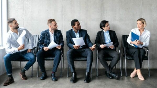 Male job applicants staring at the only female applicant while waiting for a Job Interview 