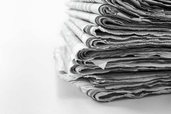 Stack of newspapers on a white surface