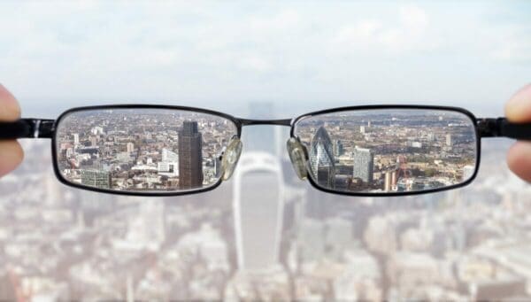 View of city though lens of a glasses held by a visionary leader