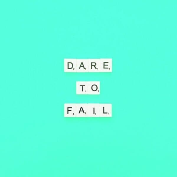 Dare to fail spelled with Scrabble tiles against blue background