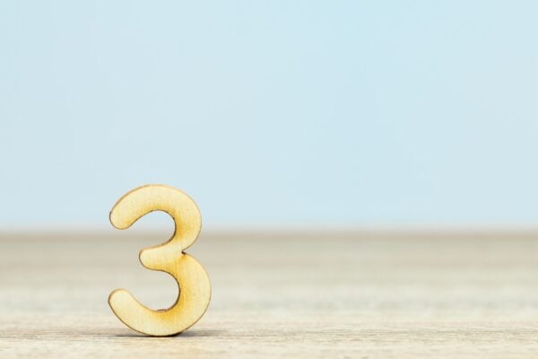 Gold number three on a beige and blue background