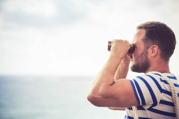 Sailor man looking through the binoculars