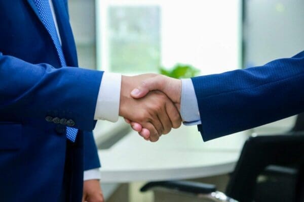 2 businessmen shaking hands agreeing after a successful negotiation