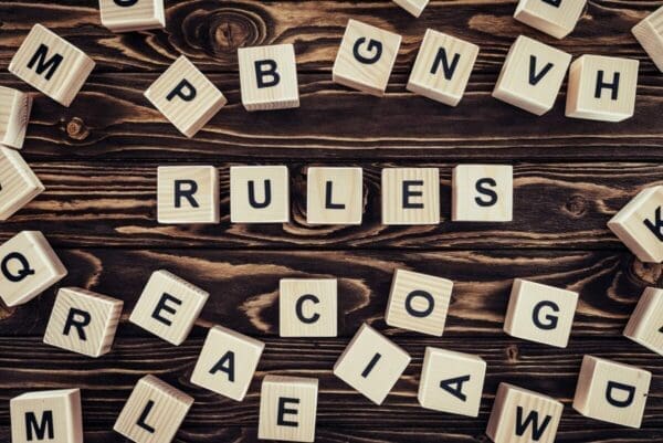 Rules spelled with wooden word scramble cubes on wooden surface