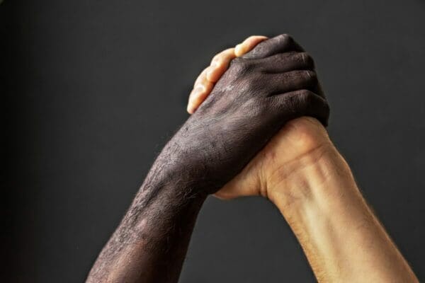 Black and white male hands represent the concept of equality and the fight against racism