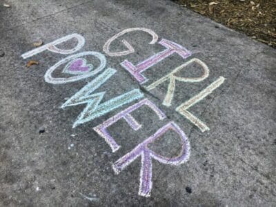 Girl Power written on the pavement in coloured chalk for female leaders