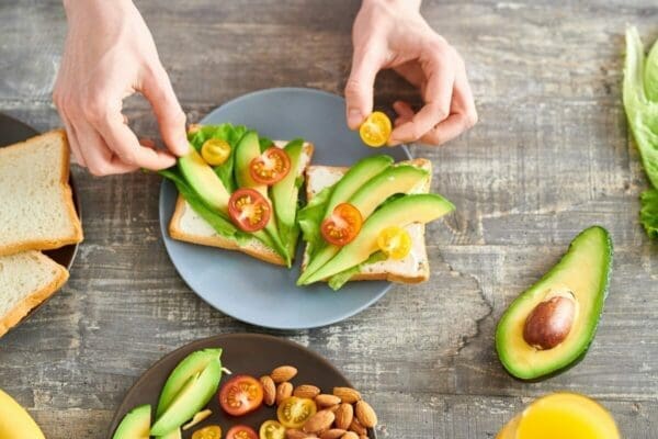 Healthy work-at-home Snack on a plate with hands adding more food