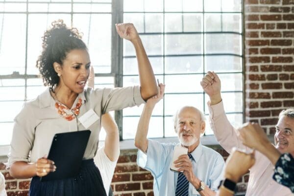 Motivational young businesswoman leader with hands in the air