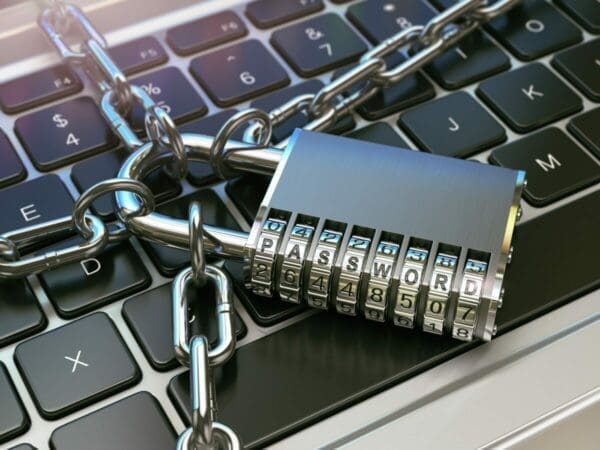 Padlock and chain across a keyboard on laptop to stay safe from cyber attack