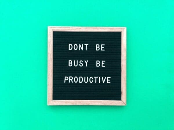 Don't be busy be productive quote on a felt board with green background
