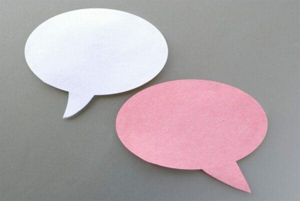 White and pink speech bubbles on a grey background
