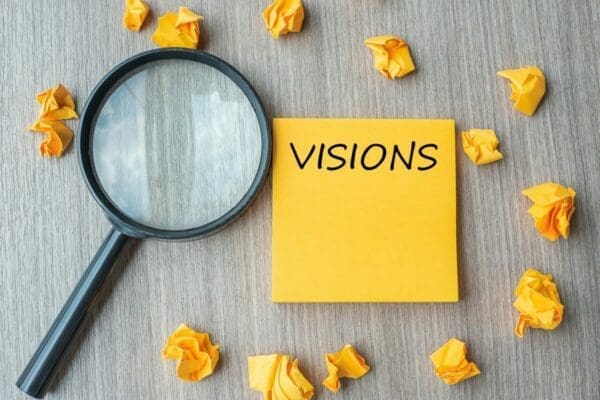 Visions written on a post-it note next to magnifying glass