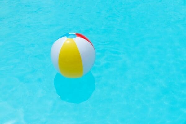 Beach Ball Floating on blue crystal water of a swimming pool