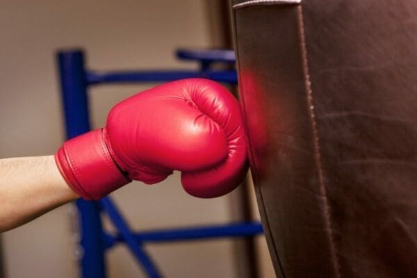 Pink boxer glove punching brown punching bag