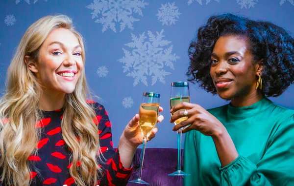 Blond caucasion woman and African American woman drinking wine and cheers