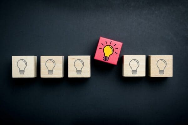 Vibrant lightbulb is separate from dull lightbulbs representing innovative thinking