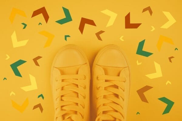Yellow sneakers with colourful arrows pointing in different directions represents decisions