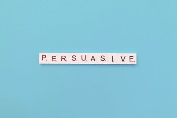 persuasive spelled with white word scramble cubes on light blue background