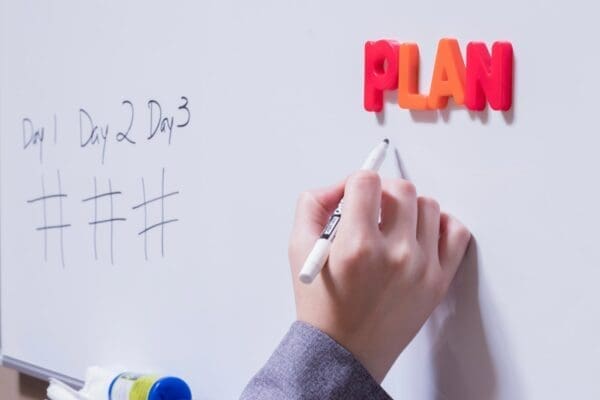 Plan spelled on a whiteboard with orange and red letter magnets