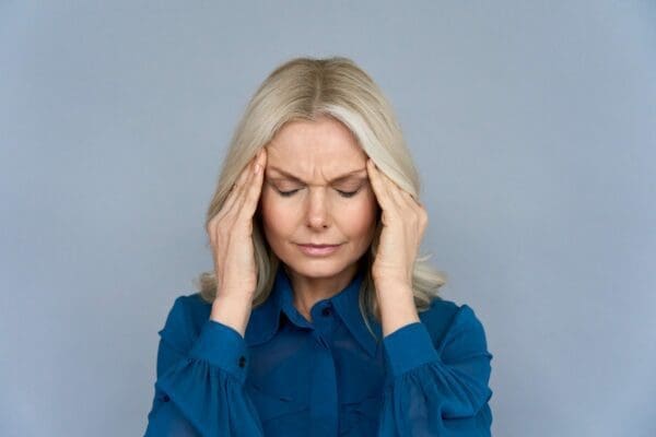 Stressed middle-aged lady suffering from headache or migraine from menopause