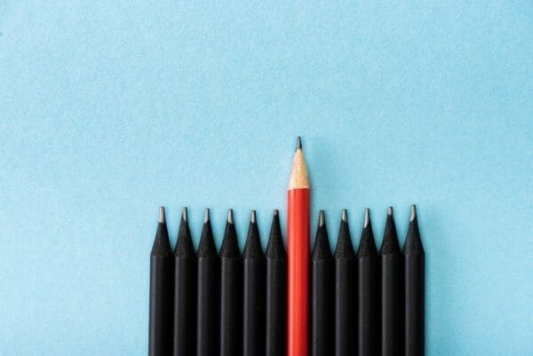 Tip of black pencil tips with the red sticking out to represent a leader