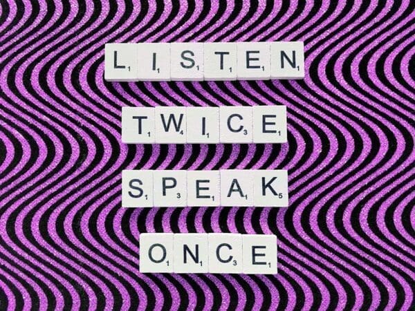 Listen twice speak once quote on wavy purple and black background