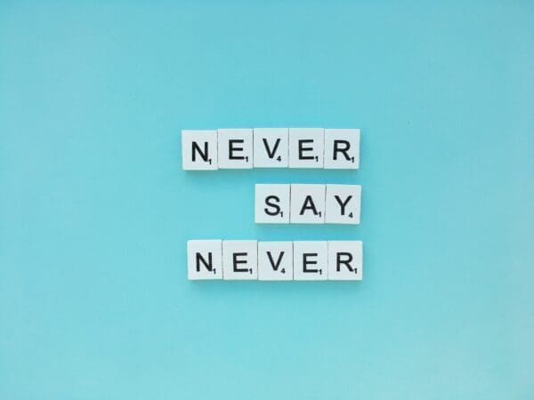 Never say never quote spelled with word scramble cubes on blue background