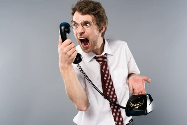 Businessman yelling through a phone during a negotiation