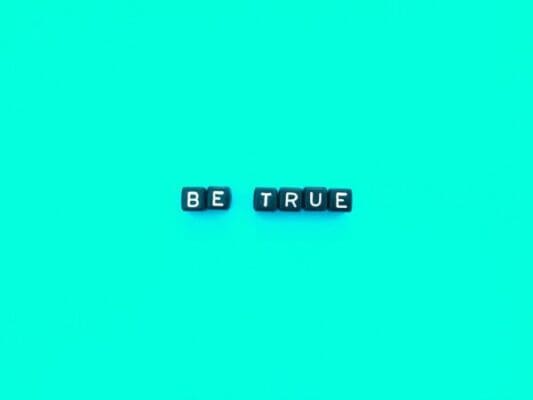 Be true spelled with black cubes on a blue background