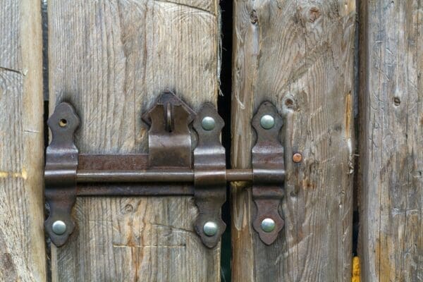 Close up of a metal deadlock on a wooden gate