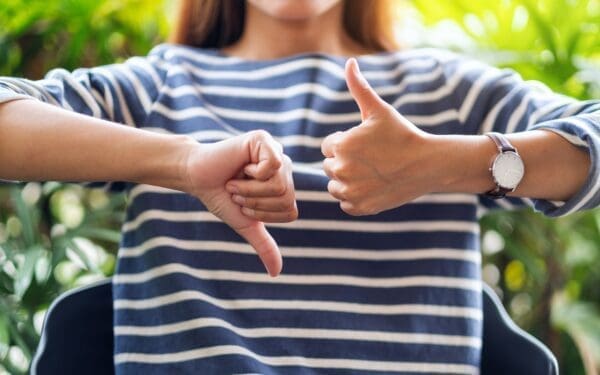 ENTJ Woman making thumbs up and thumbs down hands sign
