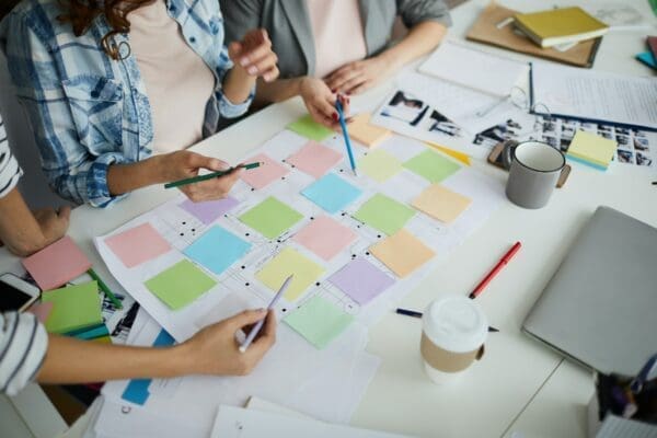 Coworkers plan together with sticky notes on a table