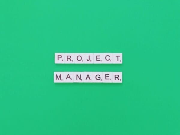 project manager spelled with word scramble cubes on a green background