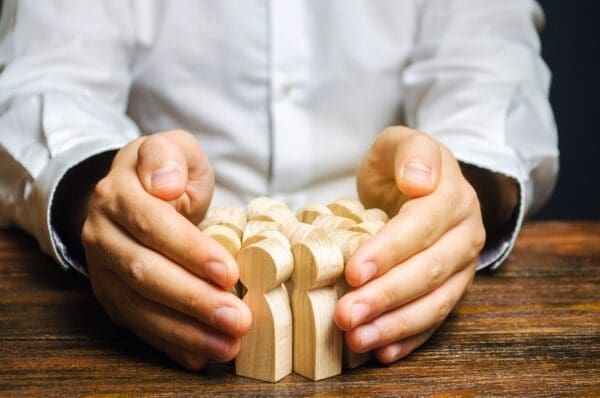 HR manager retaining wooden employee figures represents retention