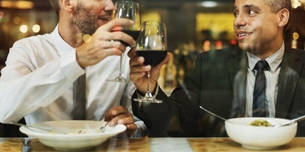 Two businessmen having wine over dinner to help teamwork