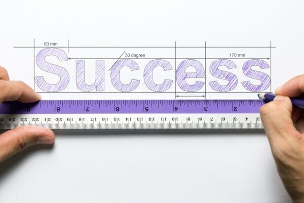 Hand measuring success with a ruler