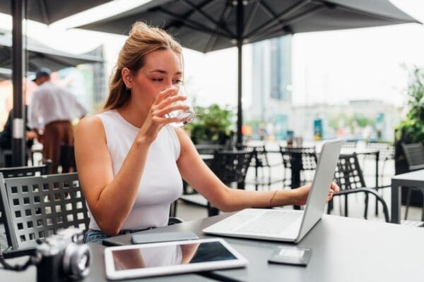 Flexible remote worker works outside a cafe with her laptop