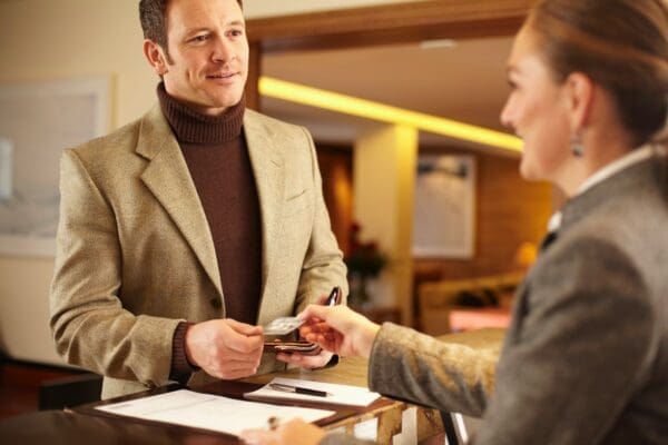 Man checking out of a hotel with female receptionist 