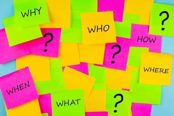 Questions and question marks written on coloured post-it notes