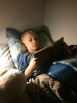 Boy reading a book before bedtime