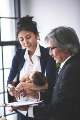 new mother businesswoman is working and holding her baby
