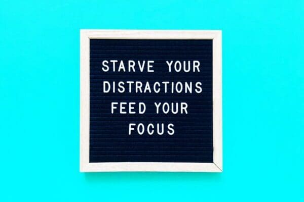 Starve your distractions feed your focus quote on blue background