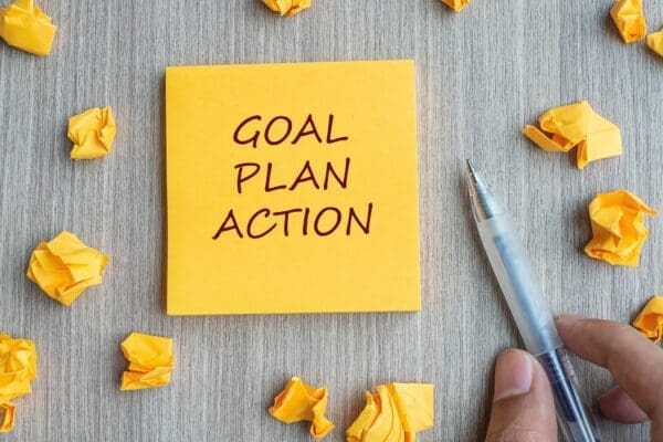 Goal plan action written on a yellow sticky note