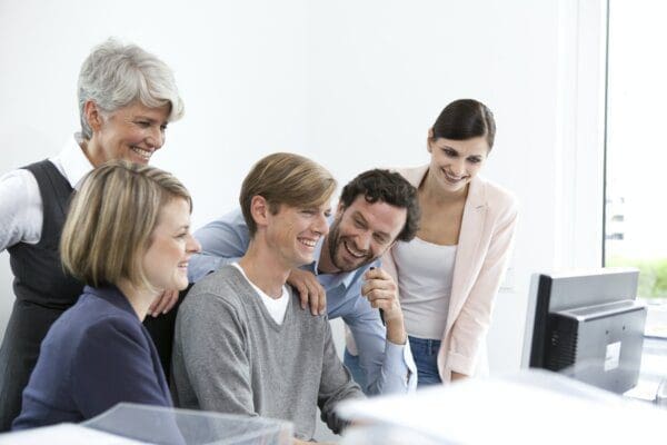 Happy business team at desk who trust one another