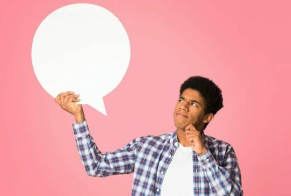 Man looking at blank speech bubble against pink background