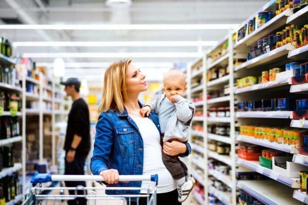 Young mother with her little baby boy at the supermarket shopping